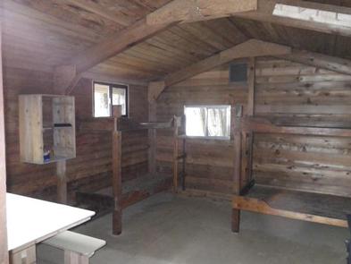Harding River Cabin wood interior with wood bunkbeds and tableHarding River Cabin interior