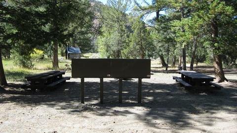 CLEARWATER CAMPGROUND OVERVIEWSign with picnic tables and restroom in the background
