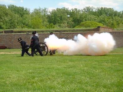Park volunteers in Civil War Union clothing firing the park's cannon.  The flame and smoke billowing out after the shot.Artillery Demonstration