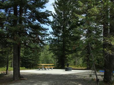 Accessible site with paved common area round fire pit, with picnic table.Accessible site
