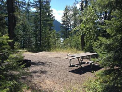 A picnic table on one of the APGAR GROUP SITES surrounded by pine treesAn Apgar group site with picnic table
