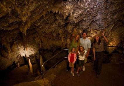 Family admiring cave formations with a rangerChimes Chamber