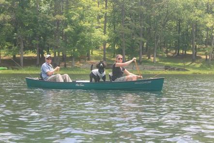 Couple taking dog for a ride in a canoe
