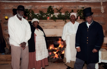 Re-enactors in the reconstructed kitchen cabin at the Old Virginia Christmas EventRe-enactors portraying enslaved people in the reconstructed kitchen cabin where Booker T. Washington was born and lived for 9 years.