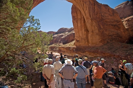 A Crowd Views Rainbow Bridge From Its ShadowIn the desert heat after the rough walk up to Rainbow Bridge from the docks, you take shade where you can get it.