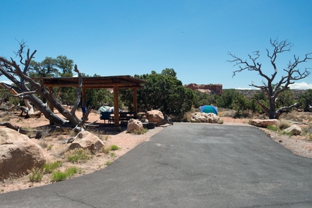CampsiteCampsites have shade structures, picnic tables, and paved parking areas.